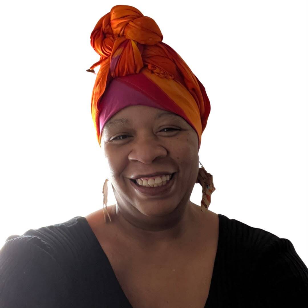 Nneka J. Hall smiling, wearing an orange head wrap
